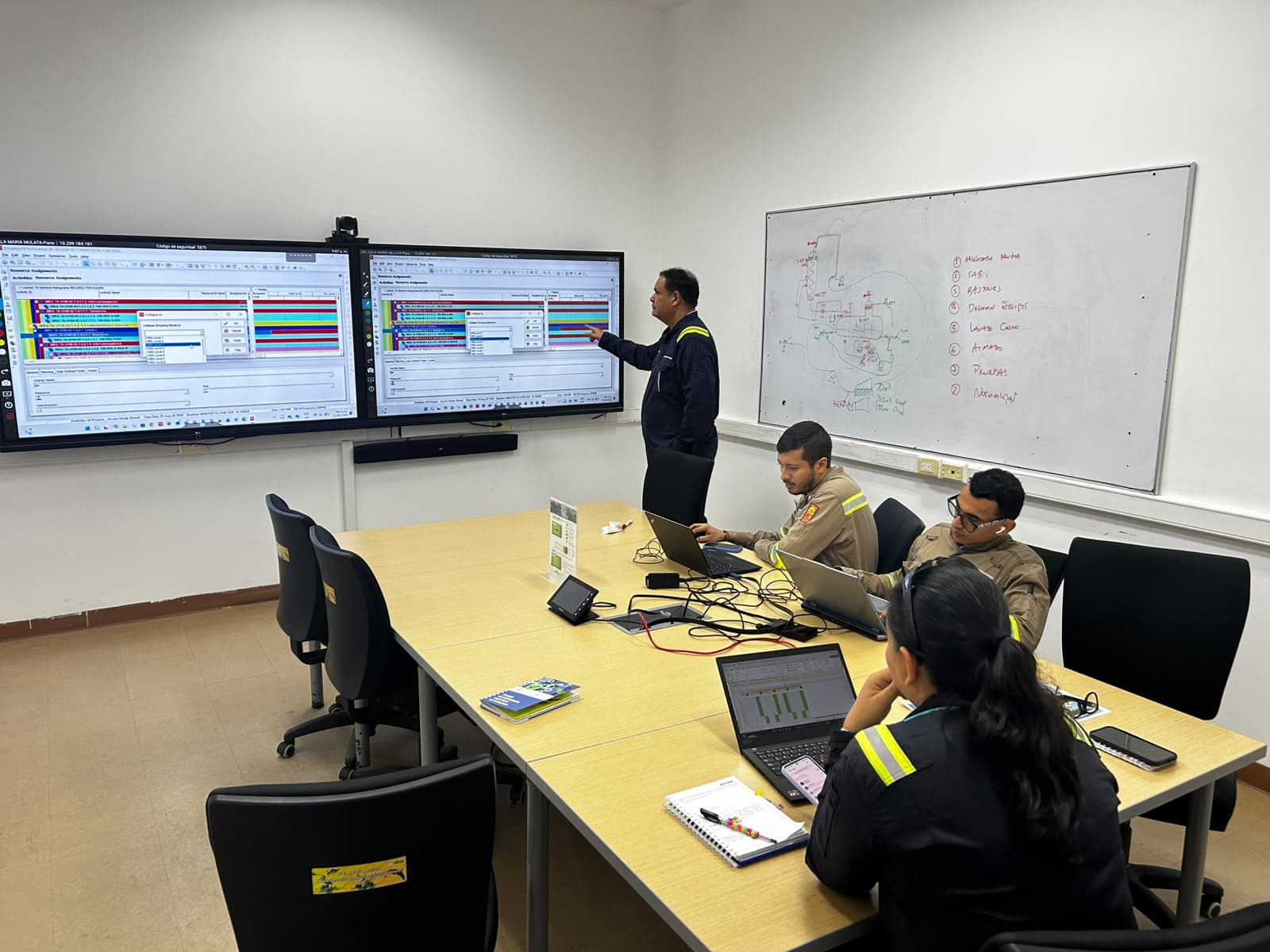 Especialistas de Proyetech capacitando en Oracle Primavera P6, con cronogramas de control de proyectos en pantalla
